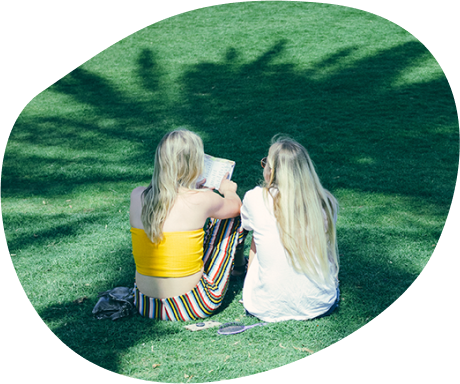 Two Coachella fans sitting on grass